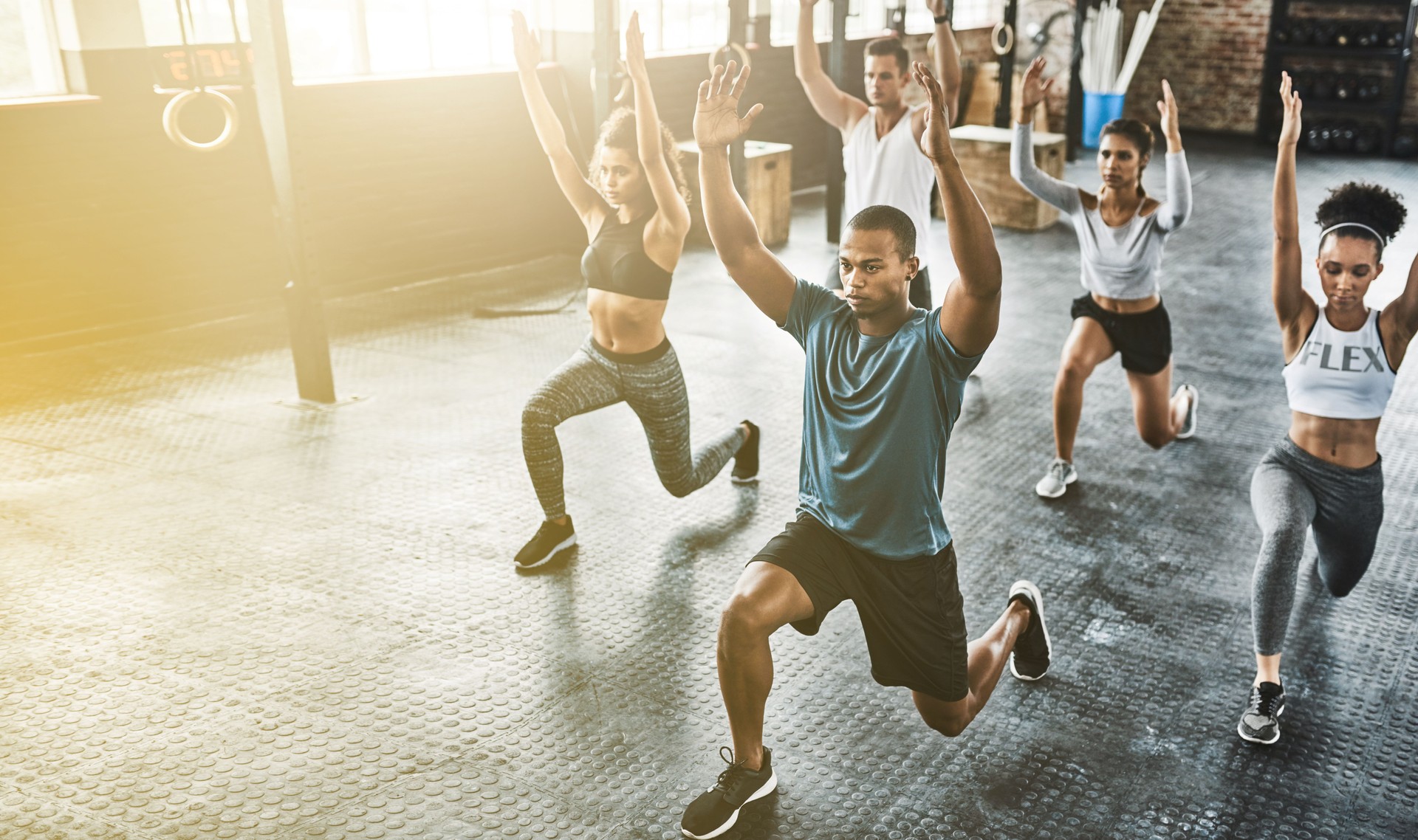 Lunge, group or people in gym with personal trainer for balance, fitness training or a healthy body. Women, men or coach instructor in exercise or workout for strong legs in wellness studio class